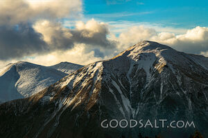 Distant mountains with snow, dramatic skies.