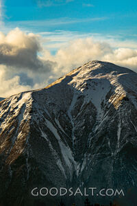Distant mountains with snow, dramatic skies.