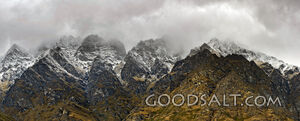 Dramatic close side of rugged wild mountain of rocks and snow.