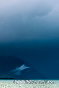 Heavy dark sky behind yellow clay cliffs.