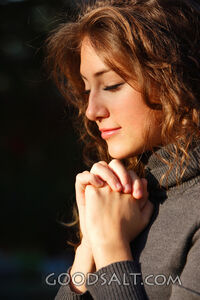 IDAHO. Boise. Young woman praying (close-up). MR