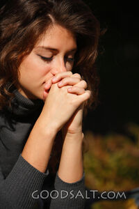 IDAHO. Boise. Young woman praying (close-up). MR
