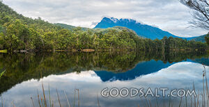 Perfect mirror reflection of forest covered banks of lake.