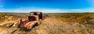 pick-up truck wreck in wide and dry desert surroundings.
