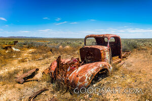 pick-up truck wreck in wide and dry desert surroundings.