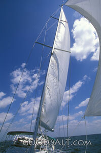 A boat sailing through the ocean with a blue sky in the background.