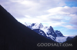 rugged snow covered peaks under cloudy sky