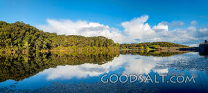 Small lake with mirror reflection and storm clouds.