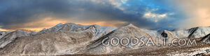 Snow covered mountain range with dramatic sky.