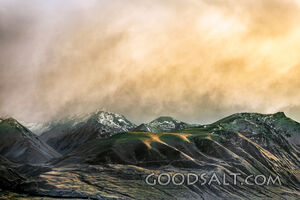 Spectacular sunrise clouds over rugged remote lake and mountains.