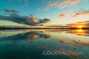 Spectacular sunset and reflection on surface of shallow lake.