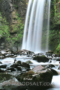 water falling into pool with rocks